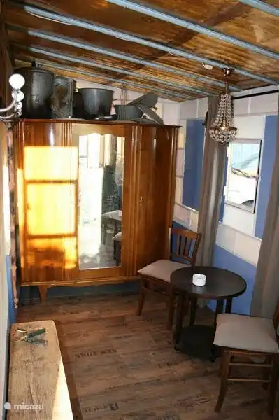 Entree in de serre met kast voor de jassen en eventueel voor de rokers een zitje.