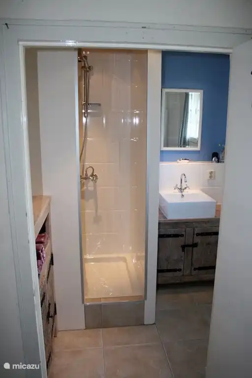 1e Badkamer op begane grond met wastafel en douche. Ernaast een separaat toilet.