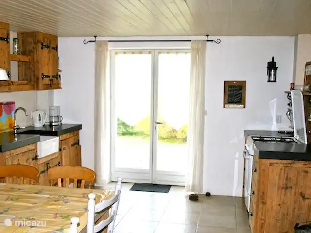 Ferme Pauchard | France, Vosges, Hennezel - maison de vacances La cuisine en vieux bois de l'ancienne grange, a accès à la terrasse. La cuisine est équipée d'une cuisinière avec four, réfrigérateur et lave-vaisselle.