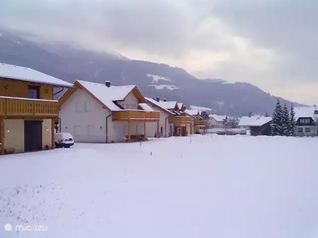 Chalet am Sonnenpiste en Austria, Carintia, Kötschach-Mauthen - chalet Todas las casas en fila en la nieve, la casa trasera es Chalet am Sonnenpiste.