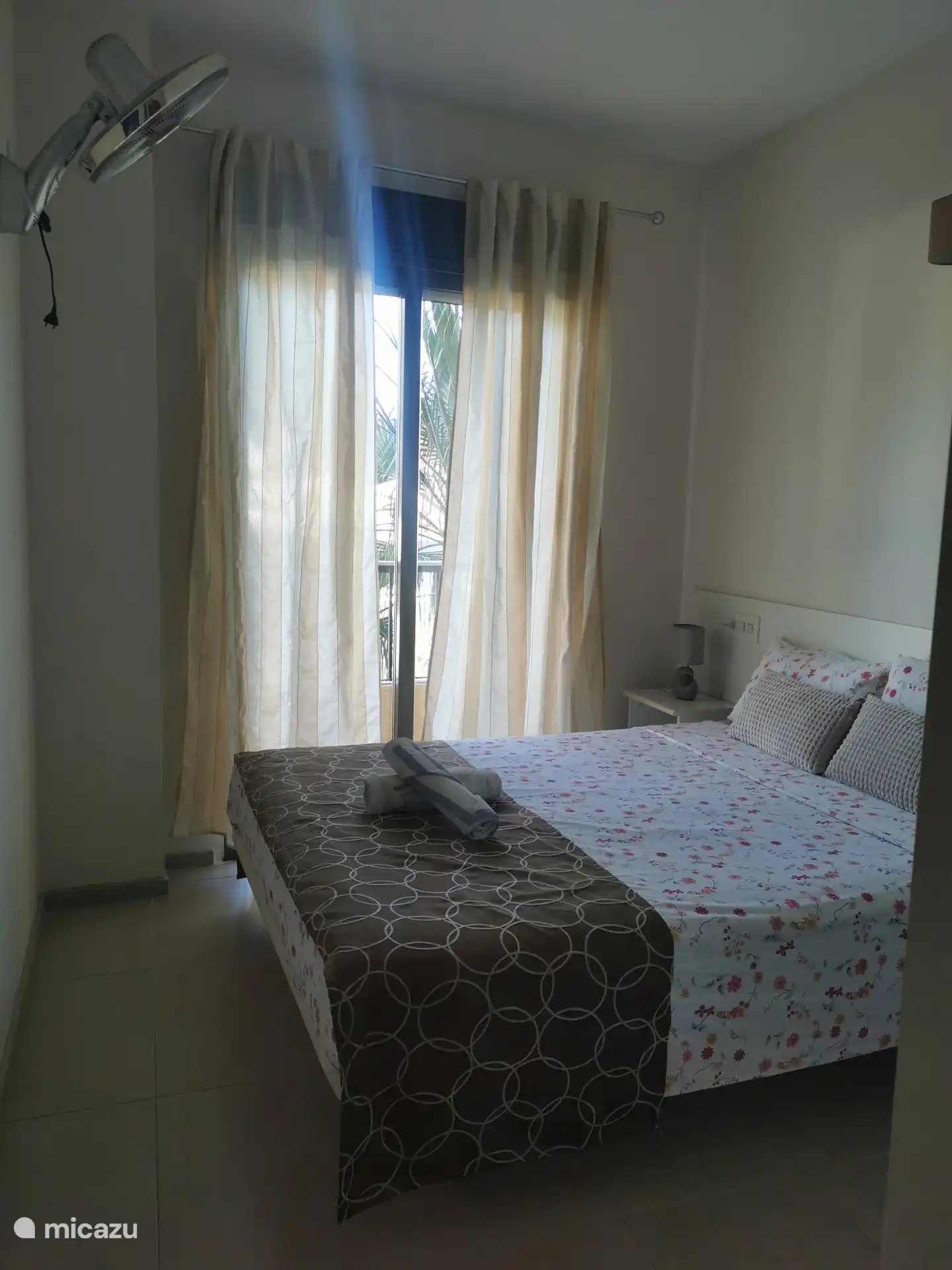 La chambre avec un lit double, un ventilateur de plafond, la climatisation est suffisante pour refroidir tout l’appartement