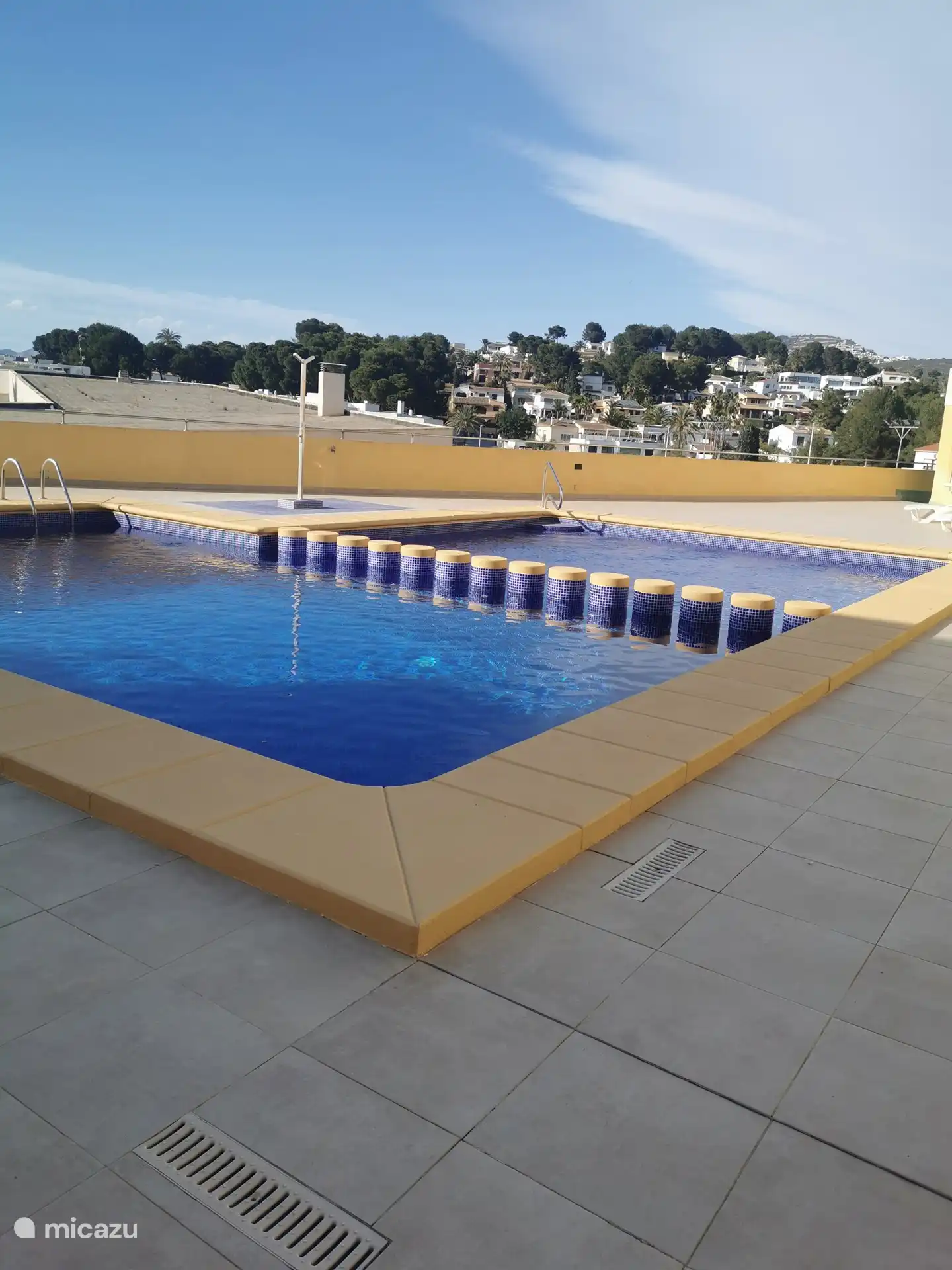 La piscine est située au cinquième étage et dispose de chaises longues pour profiter du soleil.