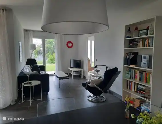 Wohnzimmer mit Terrassentüren zur Terrasse und Garten mit Blick auf den See