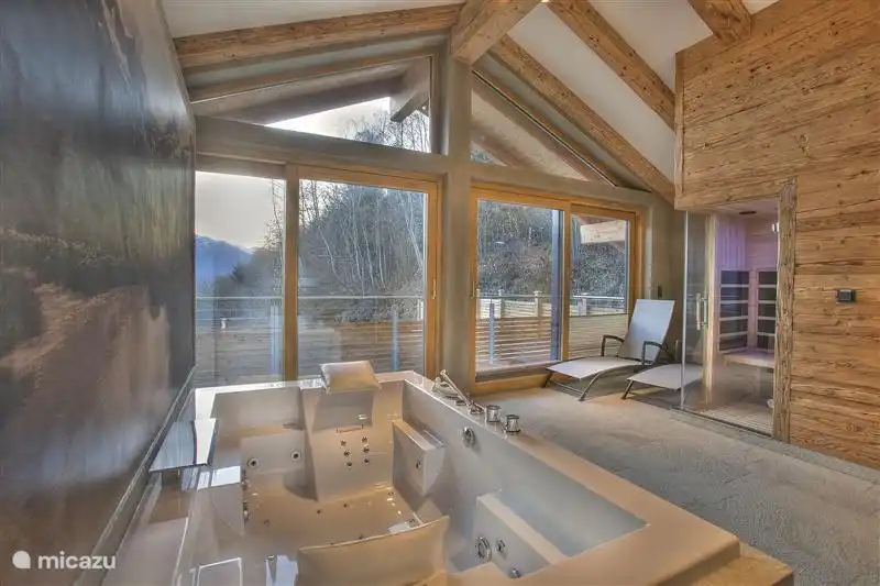 L'espace bien-être avec jacuzzi pour deux personnes, bain de vapeur, sauna infrarouge et deux luxueuses douches à effet pluie.