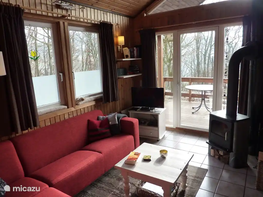 Die gemütliche Sitzecke mit Tür zur Terrasse und freiem Blick auf eine Wiese.