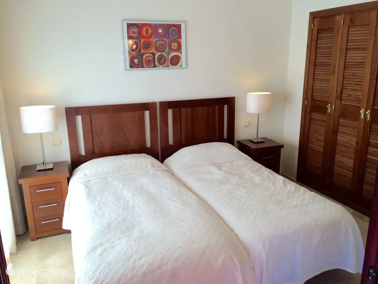 La chambre principale est adjacente à la terrasse ensoleillée et à la terrasse couverte.