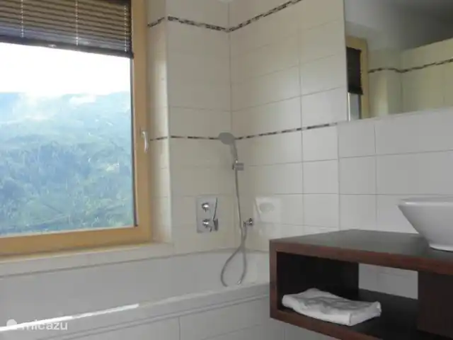 chalet huren in Oostenrijk, Salzburgerland, Bramberg am Wildkogel – Alpenchalet am Wildkogel Ruime badkamer met bad, douche, toilet en wastafel in appartement Kristall. Geniet van het uitzicht!