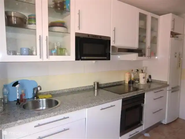 Colinas de Procusan en España, Costa del Sol, Málaga - apartamento La cocina tiene una encimera de piedra.
Desde la cocina se pasa al lavadero donde se encuentra la lavadora.