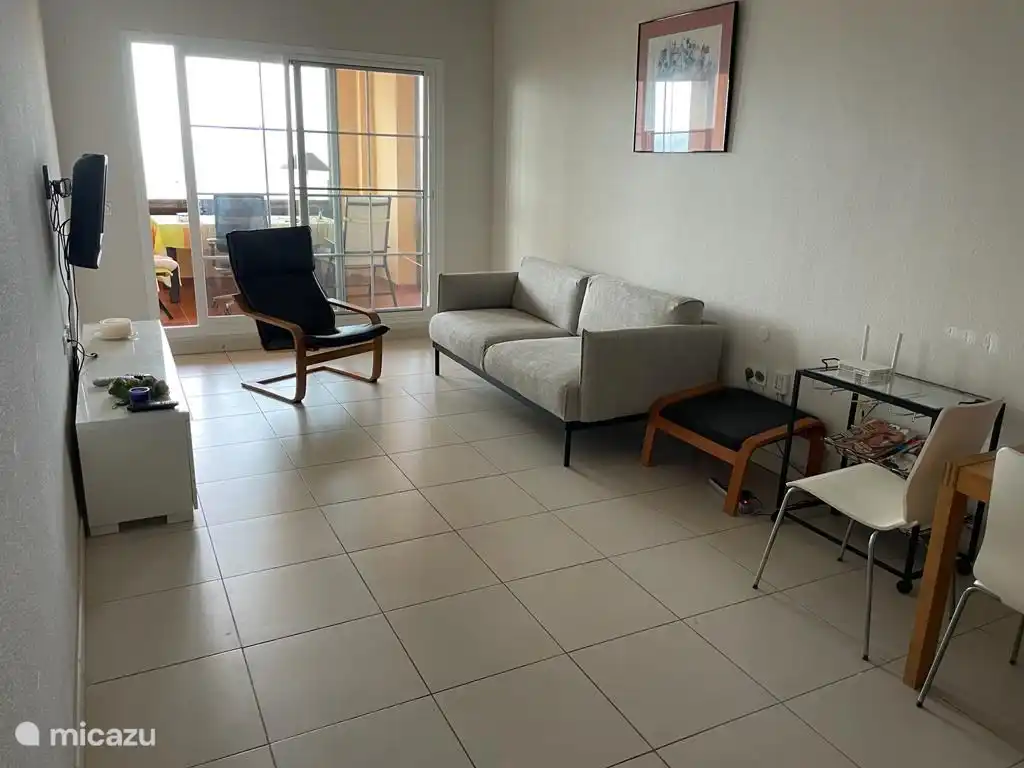 Depuis le salon, vous franchissez les portes coulissantes pour accéder à la grande terrasse avec vue sur la mer.