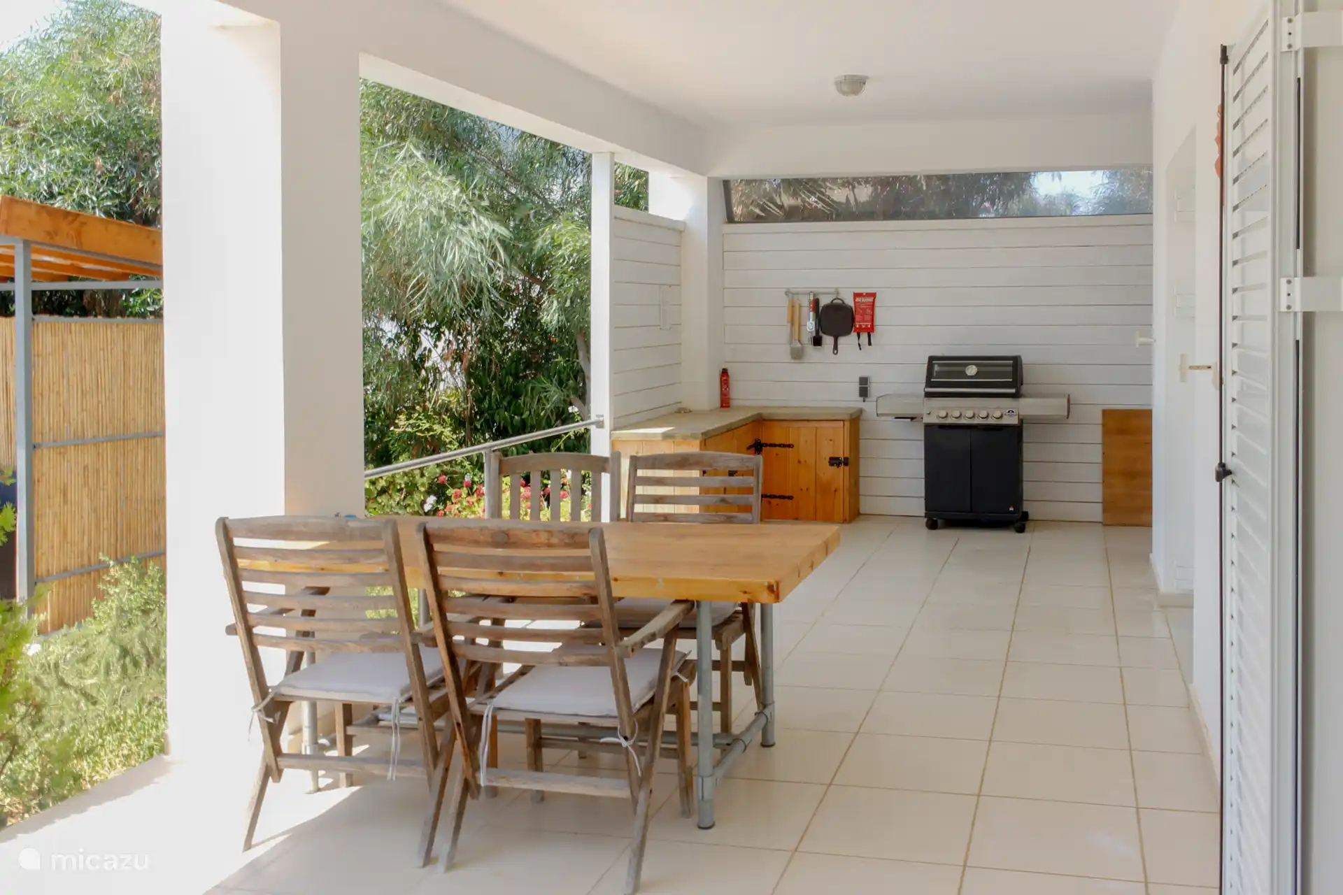 Terras beneden met gas BBQ en aansluitend aan het zwembad.