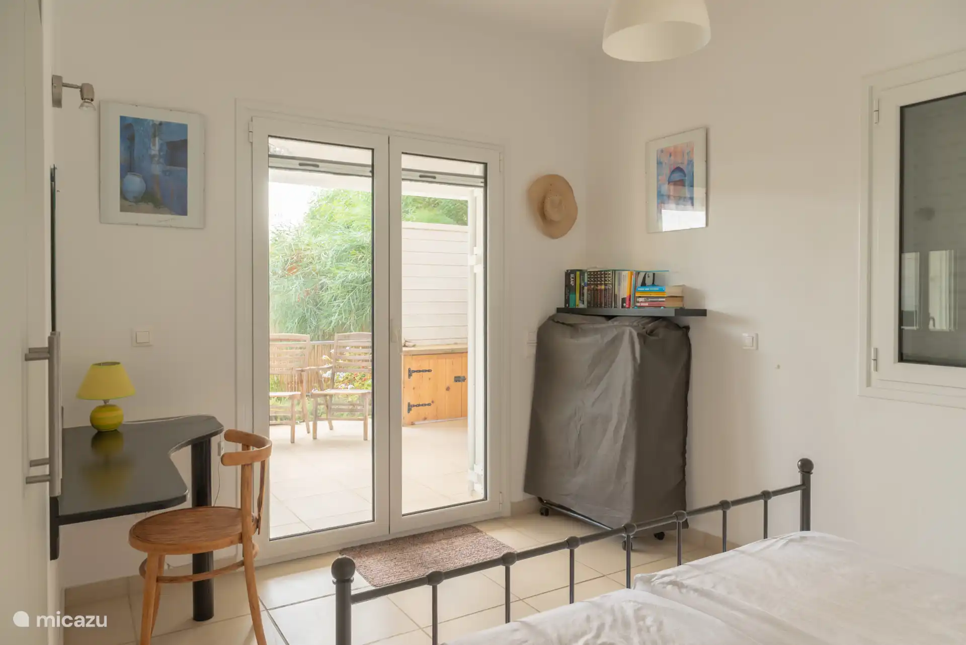 slaapkamer beneden met openslaande deuren naar het terras en het zwembad. Slaapkamers hebben luiken en horren. In deze slaapkamer is nog een extra reserve bed.