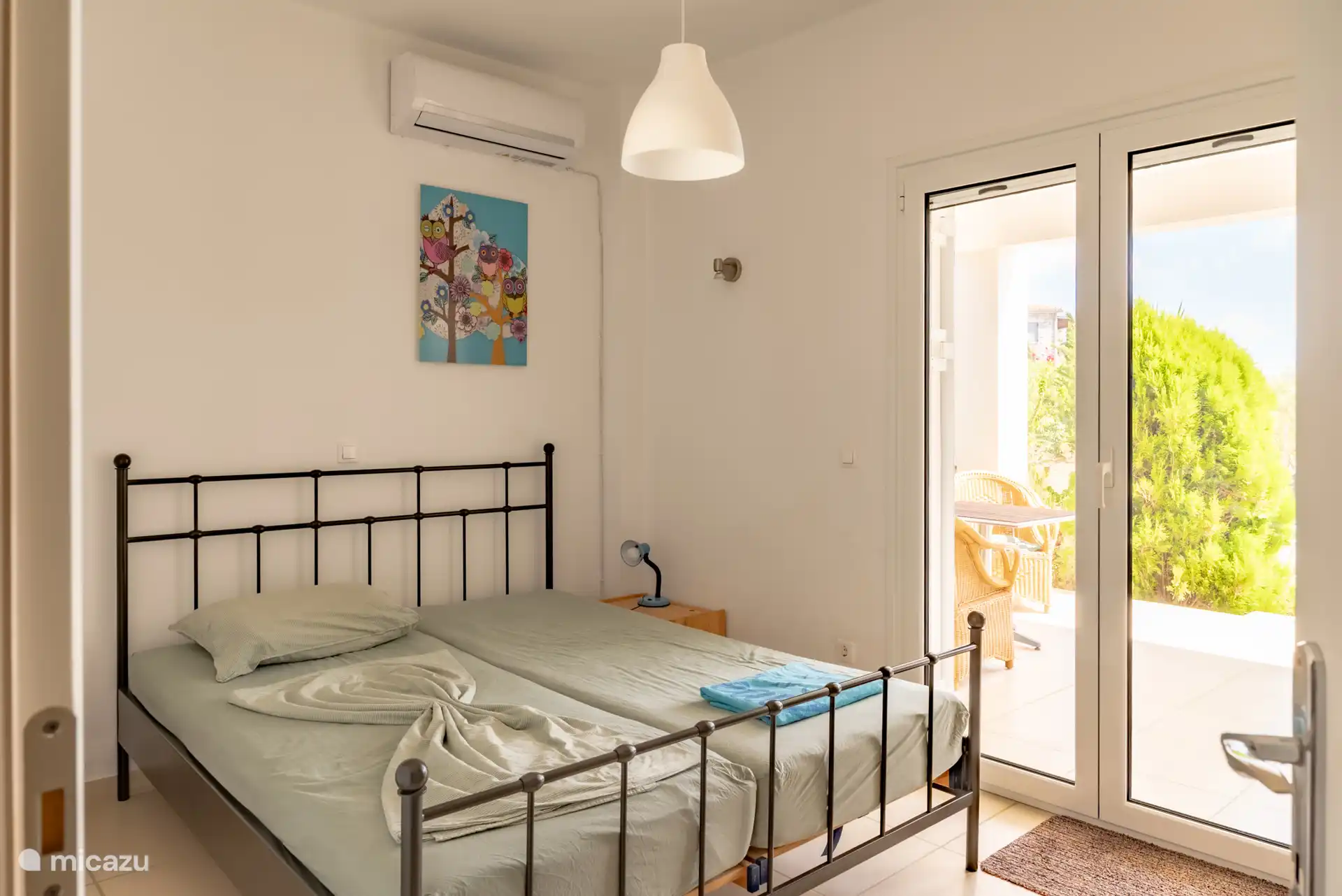 2e Slaapkamer beneden met openslaande deuren naar het terras en zwembad.