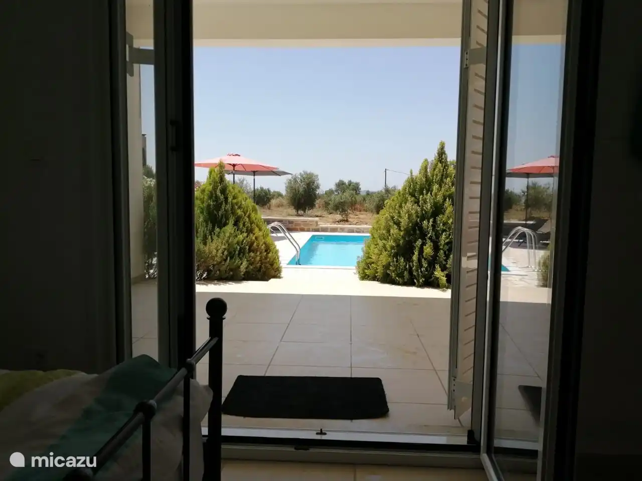 Vanuit de twee slaapkamers beneden is er direct toegang naar het zwembad en de tuin. 