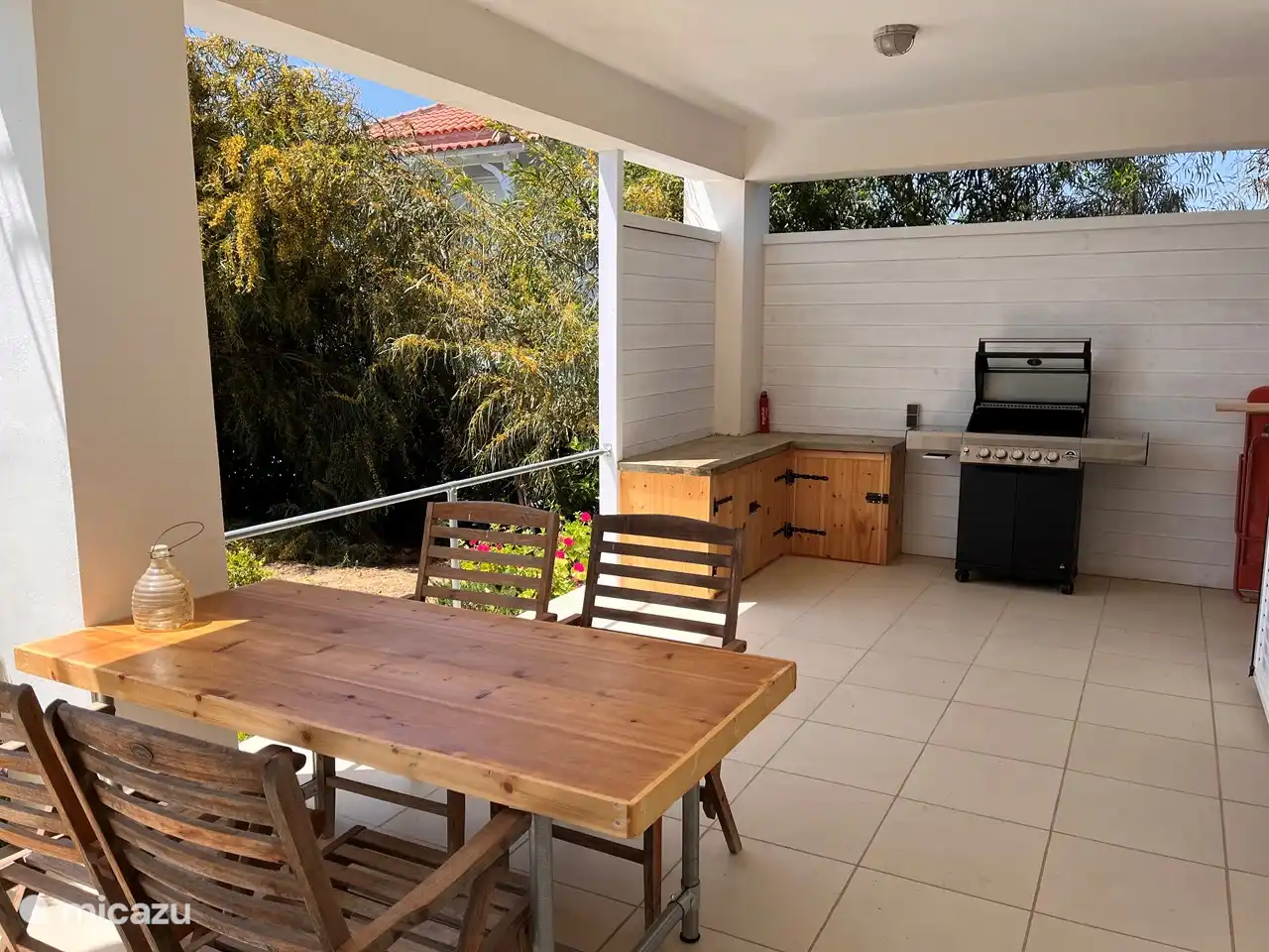 Terras beneden bij het zwembad, met buitenkeuken en gasbarbecue. Heerlijk plekje in de schaduw. 