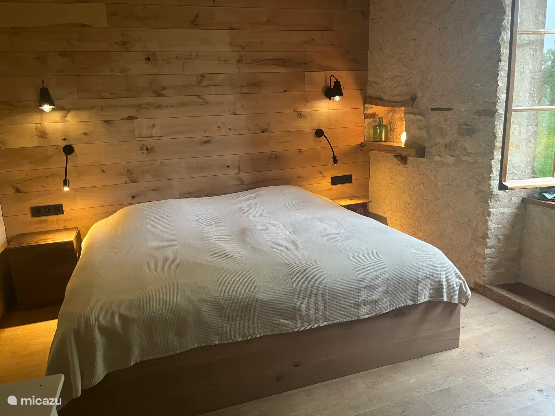 Slaapkamer King size bed, kijkend op binnenplaats 