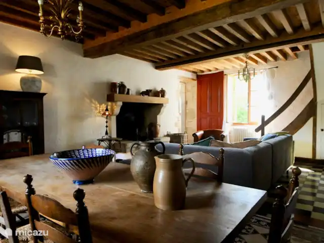 Location de Vacances France, Nièvre, Saizy, maison de vacances - Gîte Le Cochon Volant Le spacieux salon/salle à manger avec poutres apparentes d'origine. Coin salon confortable avec cheminée authentique. Grande table à manger.