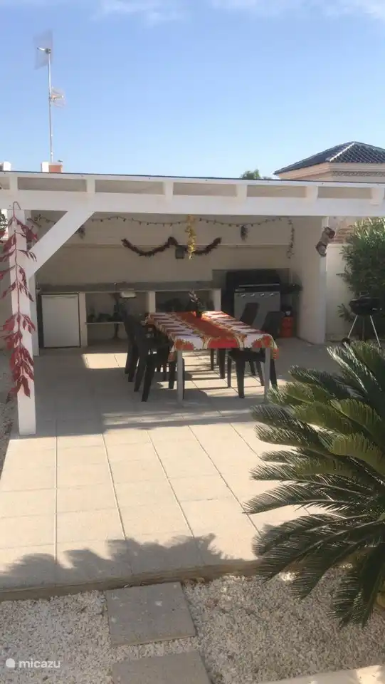 Overdekte buitenkeuken met een Elektrische en een houtskool barbecue.