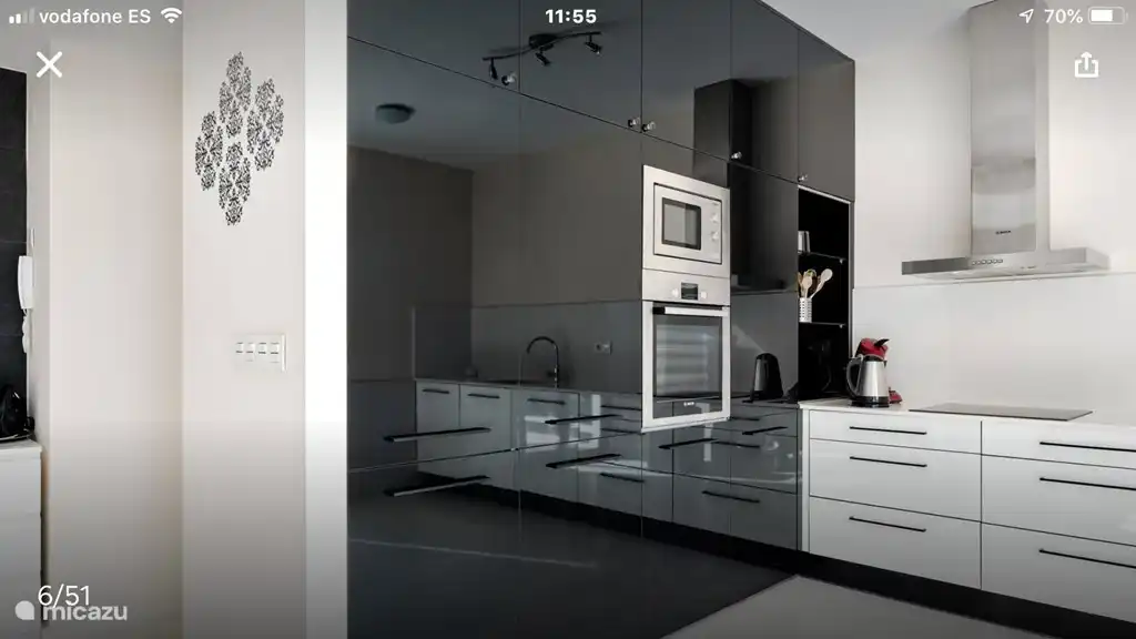 De keuken met een magnetron, grote koelkast, oven, diepvries en veel opbergruimtes