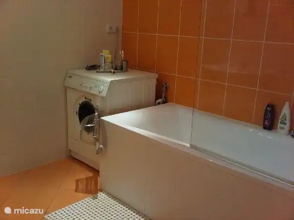 El cuarto de baño con bañera, ducha y lavadora.También equipado con calefacción por suelo radiante.