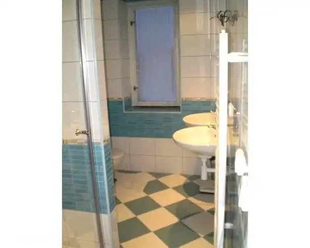 El baño completamente renovado con 2 lavabos, cabina de ducha y WC. También hay una lavadora en el baño.