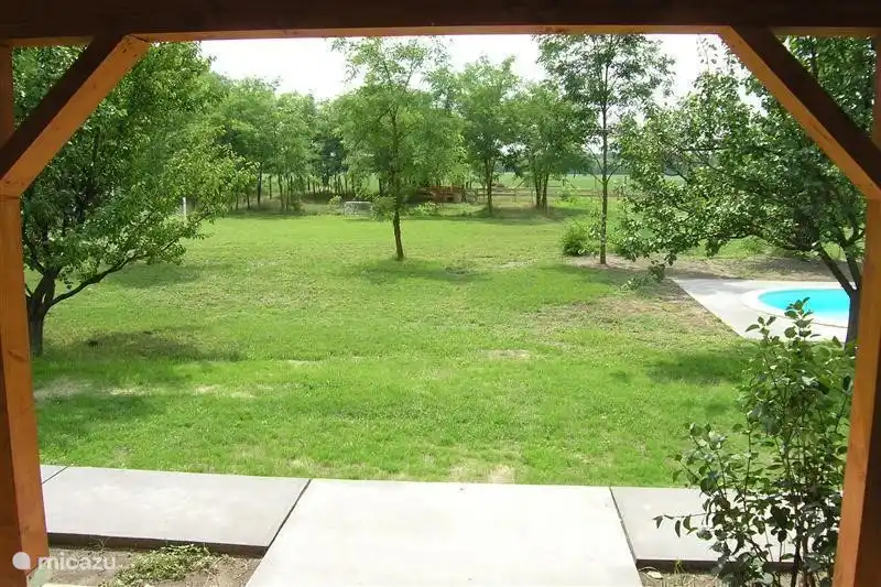Spacieuse vue de la terrasse sur le jardin et les champs.