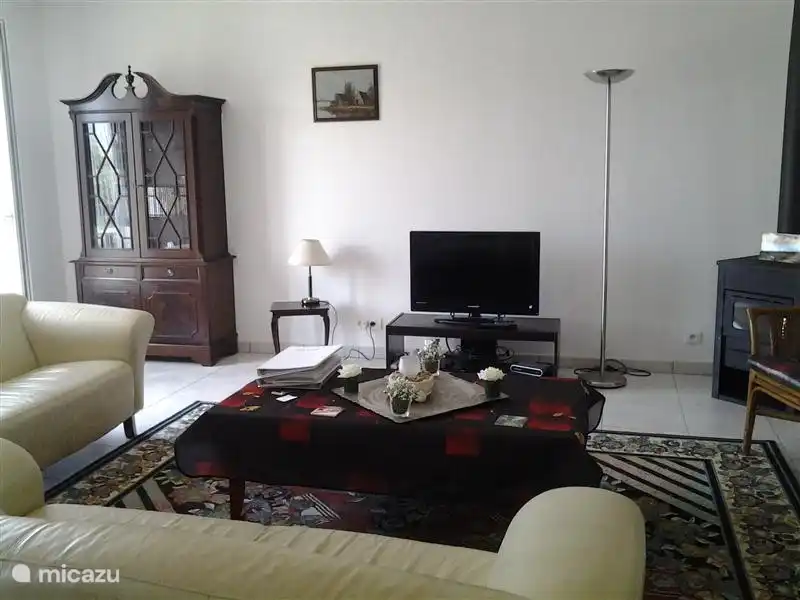 Die großzügige Sitzecke mit Vitrine, dem Holzofen für Frühling und Herbst und dem Breitbild-Flachbildfernseher (120 cm Diagonale).