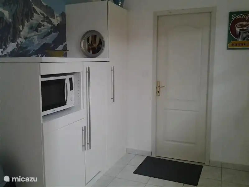 Die Mikrowelle, großer Kühlschrank und Schrank in der Küche.