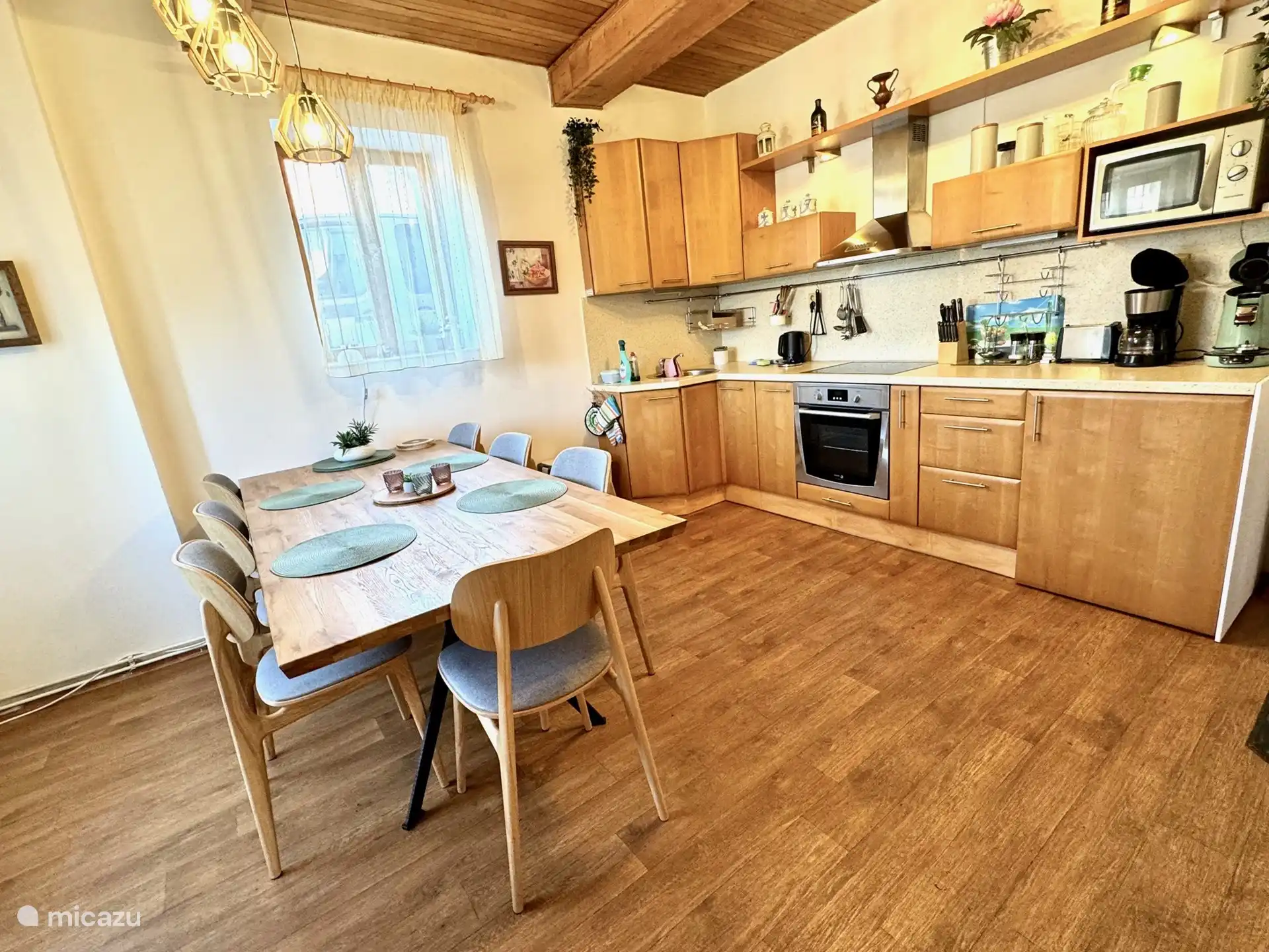 La cocina está separada de la sala de estar con un asiento en la mesa de comedor para 8 personas y hay una silla alta disponible