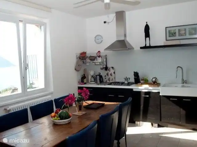 Location de Vacances Italie, Lac de Côme, Menaggio, appartement - Résidence Romana La cuisine avec table à manger spacieuse et lave-vaisselle, réfrigérateur-congélateur, four, micro-ondes, cuisinière à gaz 4 feux, hotte aspirante.