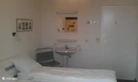La première chambre a un lit double, un placard pour les vêtements et un lavabo privé.