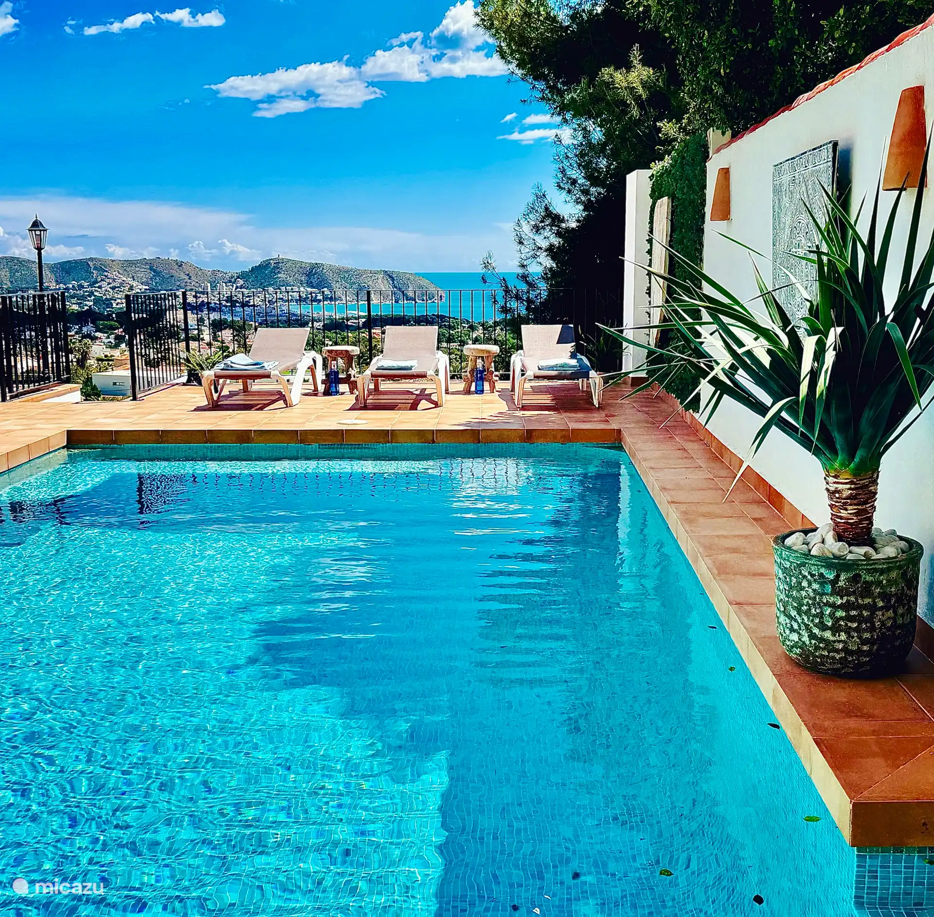 swimming pool with benches on both sides and sea view