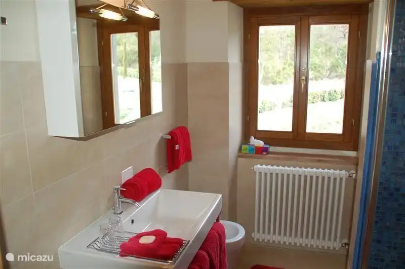 El baño perteneciente a la habitación azul con ducha, bidé e inodoro.