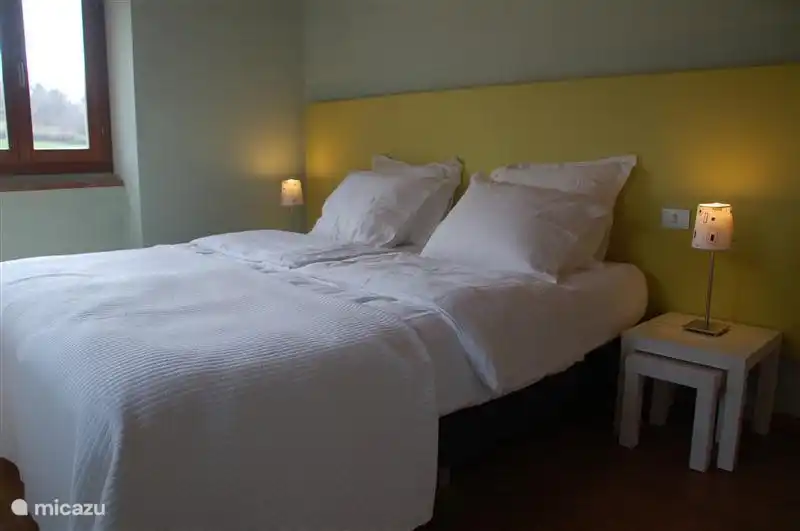 El dormitorio verde en la planta baja con cama doble.