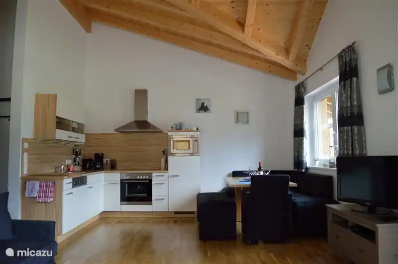 Gesamtansicht des Wohnzimmer / Küche. Das Hochdach-Finish macht es sehr geräumig. Die schönen Holzbalken sind eine Freude, ihm zuzusehen.