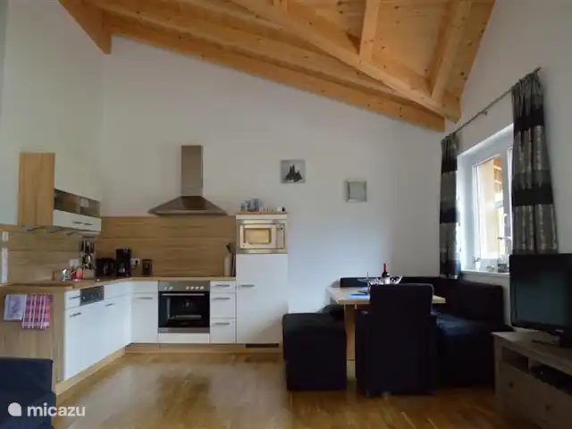 Casa Klein Rosental en Austria, Salzburgo, Neukirchen am Grossvenediger - apartamento Foto general de la sala de estar/cocina. Especialmente el acabado de techo alto lo hace muy espacioso. Las hermosas vigas de madera son un placer para la vista.