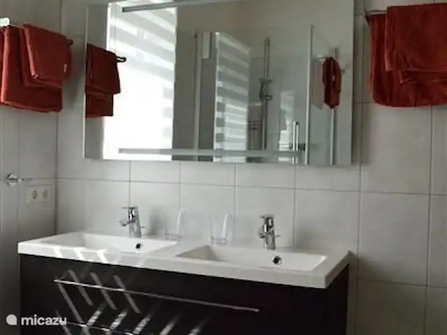 Casa Klein Rosental en Austria, Salzburgo, Neukirchen am Grossvenediger - apartamento Mueble lavabo doble con espejo y grandes cajones de almacenaje. Iluminación en el espejo.