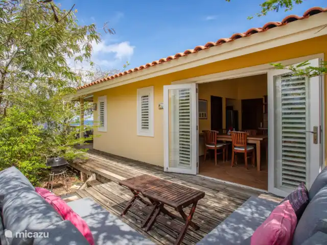 appartement huren in Curaçao, Banda Abou (west), Cas Abao – Cas Laman Abou Het is ook heerlijk relaxen op het loungeterras dat grenst aan de keuken. Van hier uit ziet u de zee door de beplanting heen schitteren.