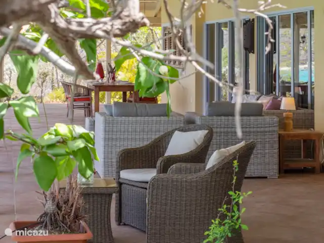 appartement huren in Curaçao, Banda Abou (west), Cas Abao – Cas Laman Abou Aansluitend aan de porch bij de slaapkamers ligt de grote porch van het woonhuis met op de voorgrond een klein zitje,....