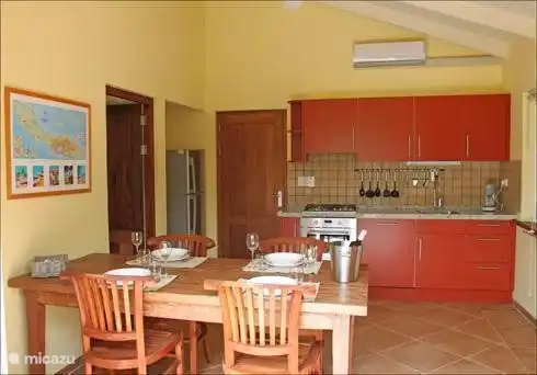 Luxuriöse Wohnküche mit schönem, geräumigem Esstisch, geräumiger Kühl-Gefrier-Kombination,  Kombi-Mikrowelle und Geschirrspüler.