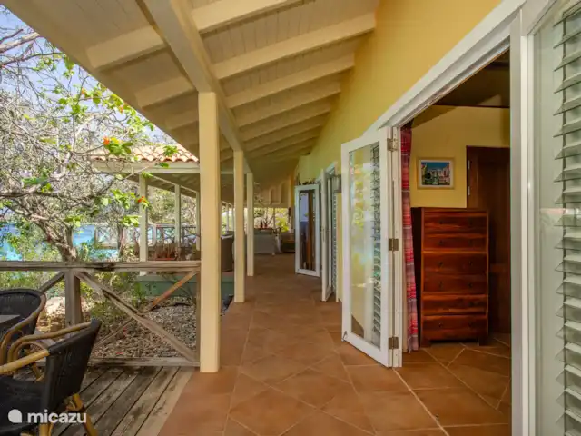 appartement huren in Curaçao, Banda Abou (west), Cas Abao – Cas Laman Abou Zicht op de openslaande deuren van beide slaapkamers en de porch bij het woonhuis. Het woonhuis is niet in gebruik als het appartement verhuurd wordt.