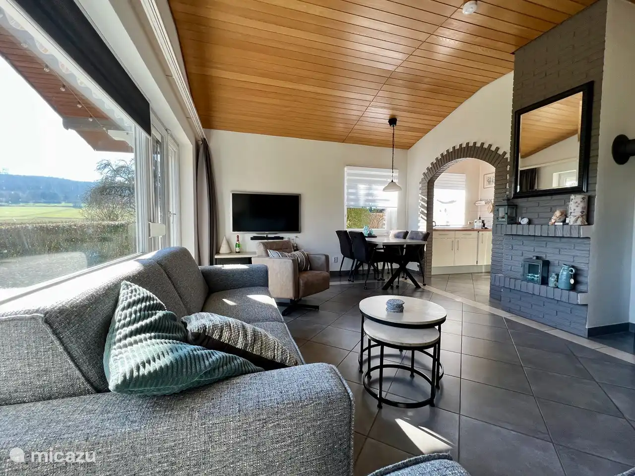 Geräumiges und helles Wohnzimmer mit bequemen Möbeln und einem schönen Blick auf die Hügel des Knull-Gebirges.