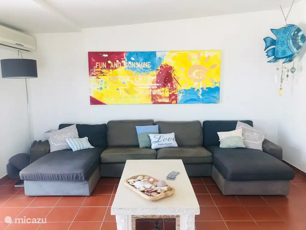 Spacieuse pièce de vie avec bel espace à vivre et cheminée. Il y a 2 portes coulissantes dans le salon semi-circulaire. Il y a des vues sur la mer partout