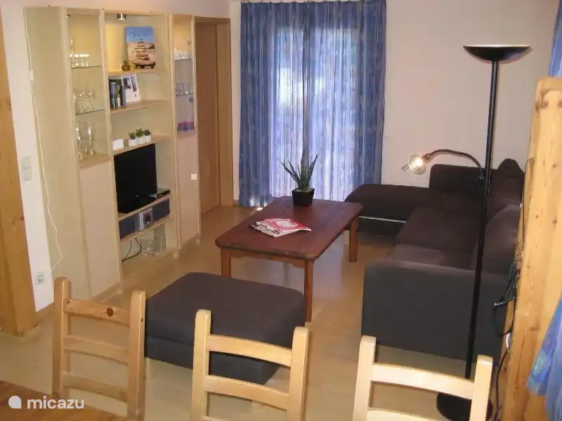 Das Wohnzimmer verfügt über ein großes Sofa und einen Sessel, einen Fernseher und ein Radio / CD-Player.