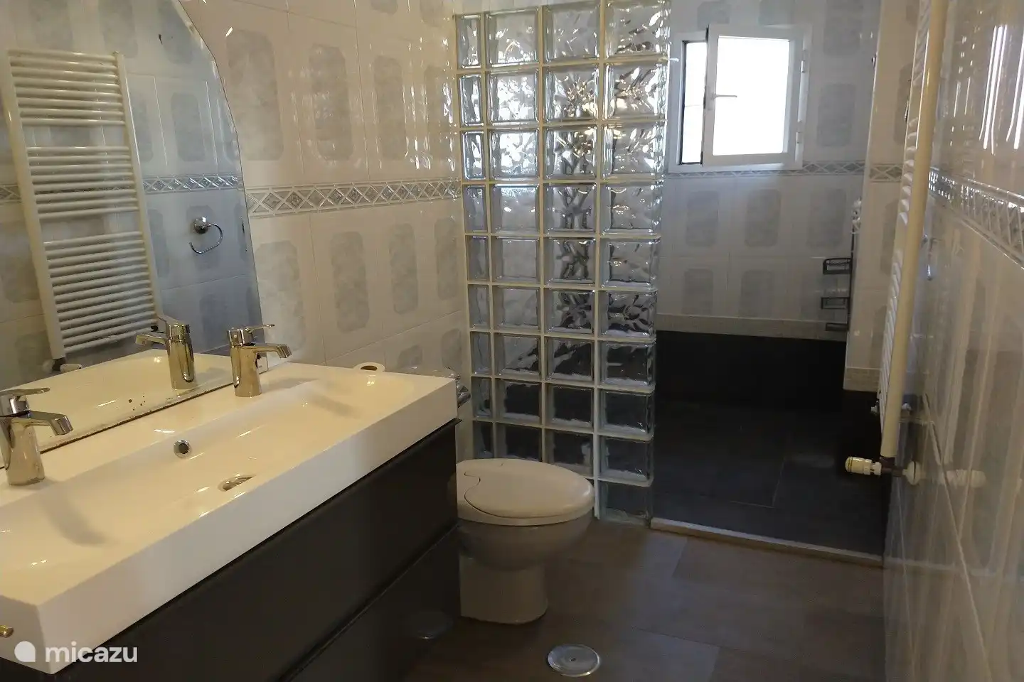 Ruime badkamer met wellness douche paneel en dubbele wastafel