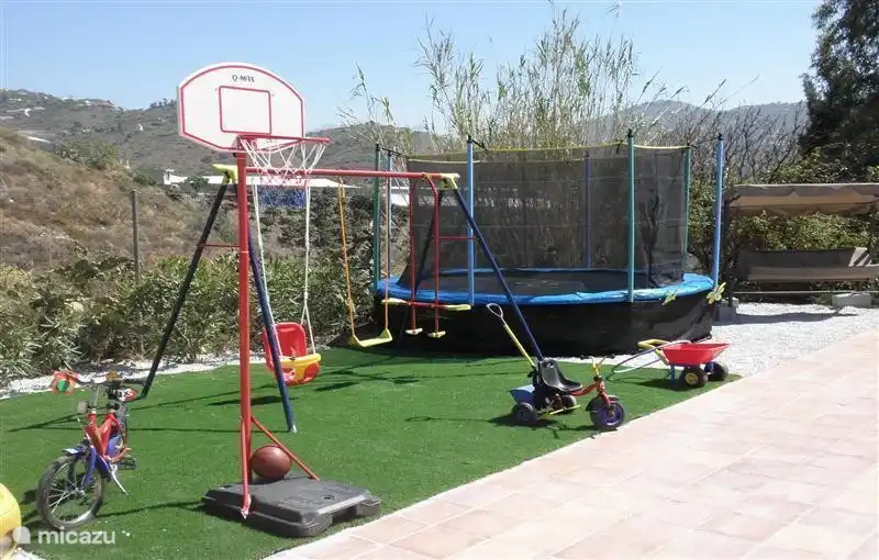 Speeltuin met schommels, grote trampoline, basket en schommelstoel