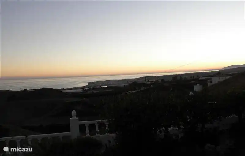 Ondergaande zon boven zee vanaf veranda