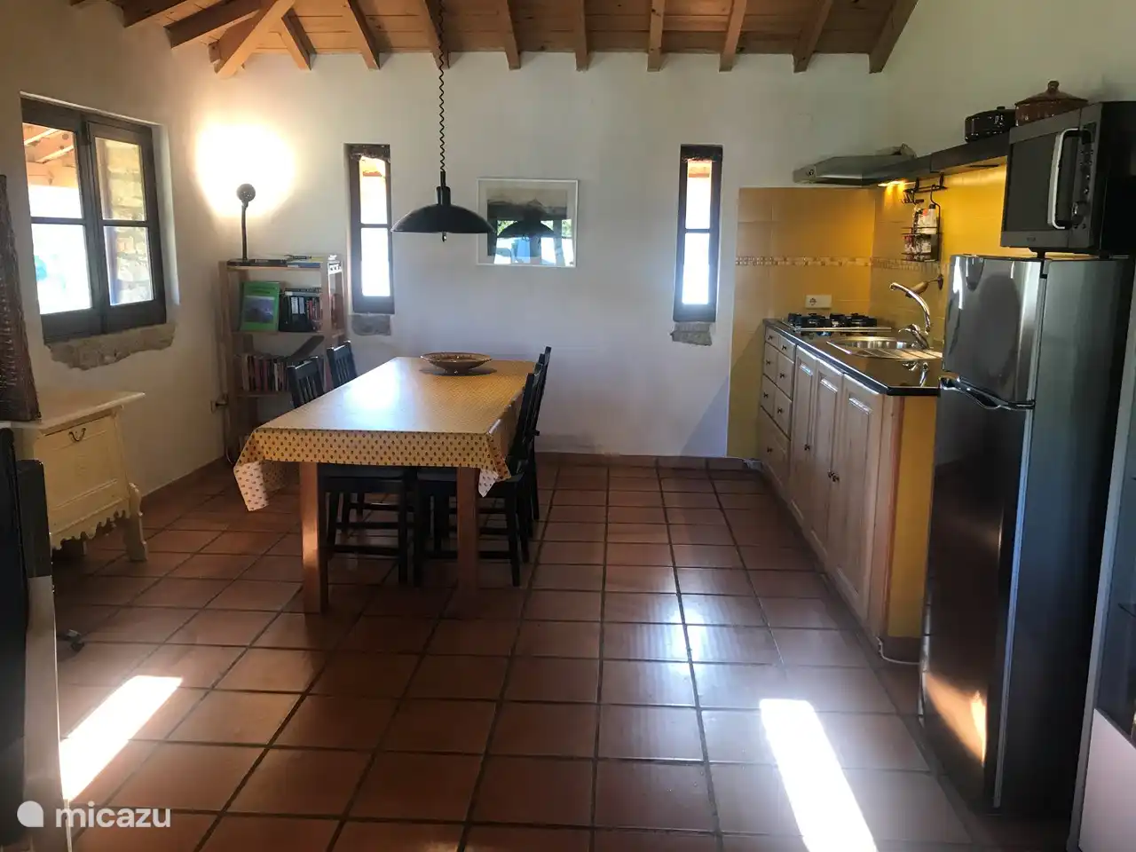 Geräumiger Esstisch in der attraktiven offenen Küche mit 4-Platten-Herd, Mikrowelle, zweitürigem Kühlschrank mit Gefrierfach.