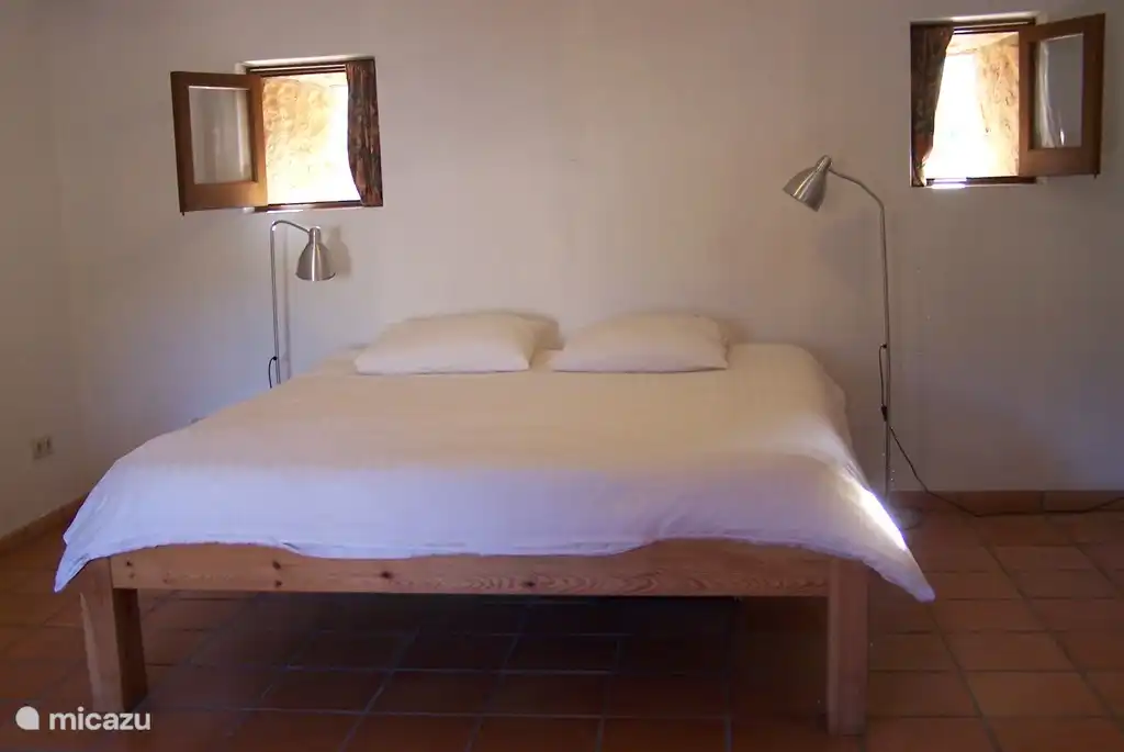 Geräumiges Schlafzimmer mit großem Doppelbett im Erdgeschoss mit Bad, WC und Waschbecken.