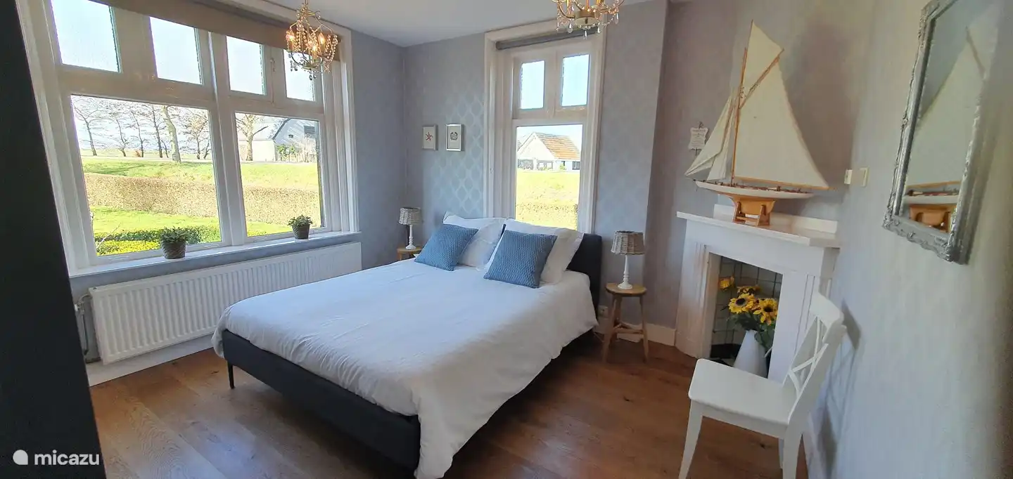 chambre lumineuse (1) en bas 1 lit double de 210x160 cm, fauteuil, cheminée authentique, penderie et penderie séparée. 2 grandes fenêtres.