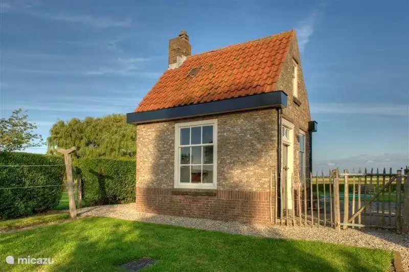 Arrière maison, bâtiment classé. Voici un kart, tricycle, etc. De plus, il y a une dépendance qui sert de buanderie avec lave-linge, sèche-linge, réfrigérateur/congélateur supplémentaire et où vous pouvez mettre vos vélos.